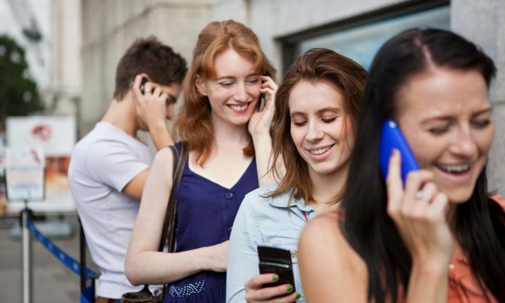 Young men and women using mobile phones