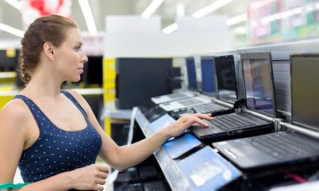 woman looking at laptops in store
